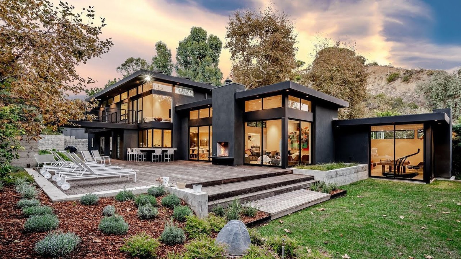 Modern luxury home with wood deck and floor-to-ceiling windows
